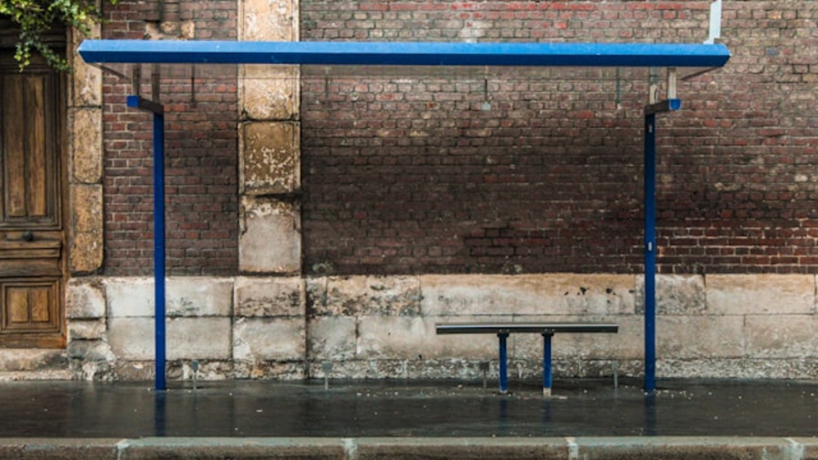 Empty blue bus stop in the rain