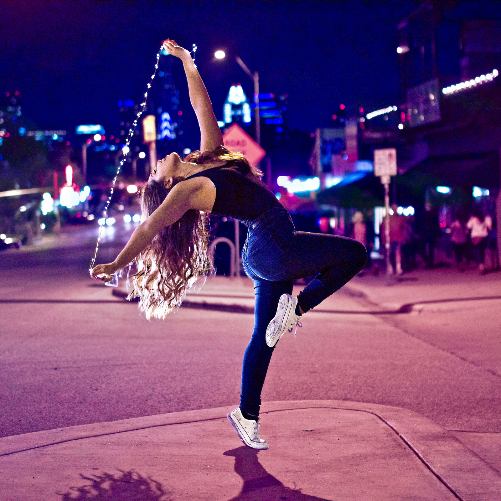Woman dancing on the street at night