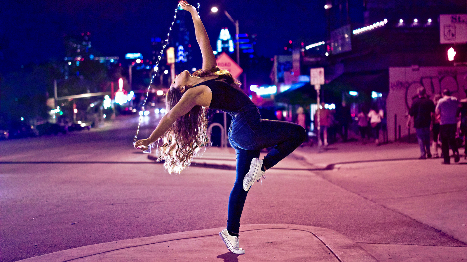 Woman dancing on the street at night