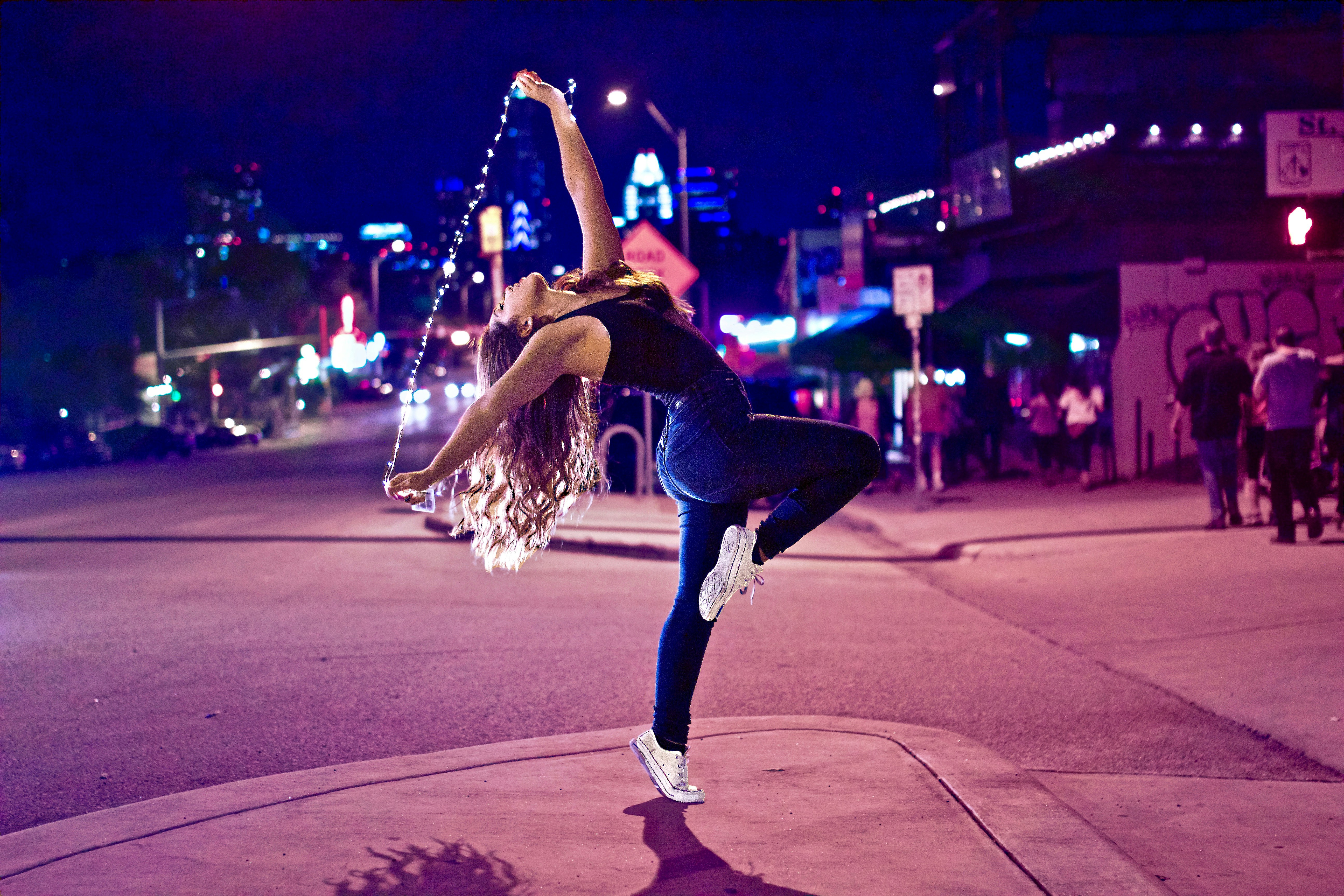 Woman dancing on the street at night
